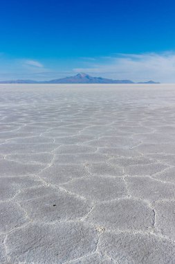 Salar de Uyuni, Bolivya 'da dağlarla birlikte tuz düzlüğü altıgen dokusu.