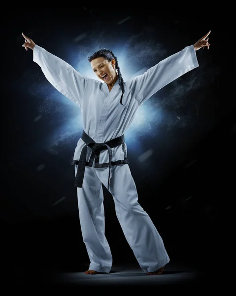 Professional female karate fighter isolated on black background