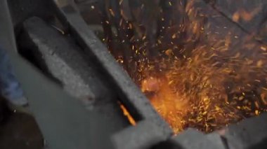 Görüntü, metali ateşle eritme sürecini gösteriyor. Maddenin yoğun ısı ve dönüşümünü vurguluyor..