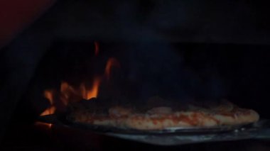 Fırına giren bir pizza gibi pişirme işlemi. Bu görüntü mutfak sanatının özünü ve mükemmel bir pizza hazırlama sürecinin detaylarını yansıtıyor. Yemek pişirme, ev yapımı tarifler ve pişirme sanatı.
