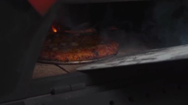 Karidesli pizza tamamen odun ateşiyle pişmiş, geleneksel yemek pişirmenin mükemmelliğini yakalıyor..