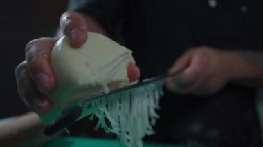 Peynir rendesinin bir tarife mozzarella ekleyip rendelenmiş peynirin tazeliğini ve kalitesini gösterdiği anı yakalar.