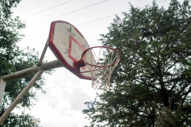 Basketbol tahtasının detaylı çekimi, kentsel ve doğal elementleri birleştiren bir ortamda çekildi. Tahtanın ayrıntıları ve çevreyle bütünleşmesi göze çarpıyor., 