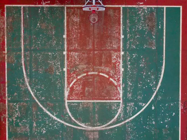 Basket sahasının tek taraflı atışını, saha çizgilerine odaklanarak yapıyor. Bu perspektif, yerdeki işaretlerin hassasiyetini ve tasarımını vurgular, mahkeme planının ayrıntılı bir görünümünü sunar.