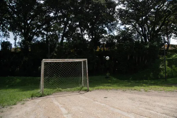 Boş bir gol ve gol atmak üzere olan bir futbol topu, tam kalenin kenarında.