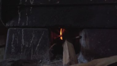 Geleneksel yemek pişirmeyi temsil eden bir odun sobasının üzerinde kil bir komal. Ormanın sıcaklığı tortilla pişirmek için mükemmel bir ortam sağlarken, duman havaya yükseliyor..