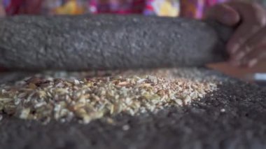 Öğütme taşının geleneksel kullanımı, susam, kabak tohumu ve guaque chili 'nin işlendiği yerde gözlemlenir. Bu zanaat metodu malzemelerin lezzet ve dokularını yoğunlaştırır.