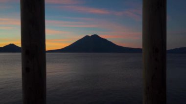 Atitlan Gölü 'nden gün doğumu. Arka planda volkanlar var. İskelede.