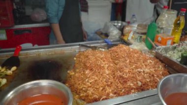 Carne al pastor sıcak bir ızgarada pişirirken, denizciliğini ve pişirme sürecini ön plana çıkaran altın tonlarıyla, iştah açıcı bir koku yayıyor..