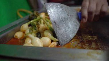 Sıcak ızgarada soğan pişiyor, yoğun bir aroma yayıyor ve altın rengine dönüşürken karamelize oluyor..