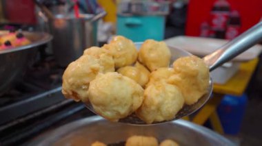 Taze kızarmış böreklerin yakın çekimi, altın ve çıtır çıtır yüzeyi vurguluyor, hala sıcak ve bal ile eşlik edilmeye hazır. Geleneksel mutfağın tipik bir lezzeti, festivallerde ve festivallerde eğlenmek için mükemmel..