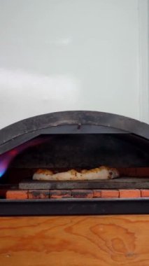 Bir pizza fırındaki mükemmel pişirme noktasına ulaştı. Ekmeği mükemmel kavrulmuş ve erimiş peynir kaynıyor. Pepperoni ve fesleğen gibi tepeler, tadını çıkarmaya hazırdır..