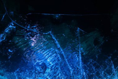 Close up photo texture of frozen dark and cracked water surface.