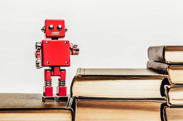 Foto Buku Antik Tua Menumpuk Dengan Mainan Robot Merah Berdiri — Stok Foto