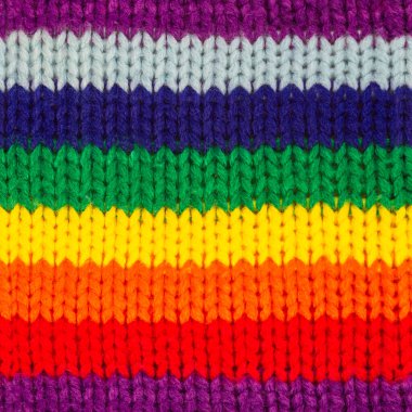 Canlı gökkuşağı renginde örülmüş yün süveter kumaşının pürüzsüz 4k fotoğraf dokusu.