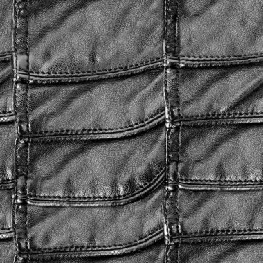 Dikiş atılmış, siyah renkli ve cilalı deri yüzeyli, kusursuz 4k fotoğraf dokusu. Zırh dokusu materyali.