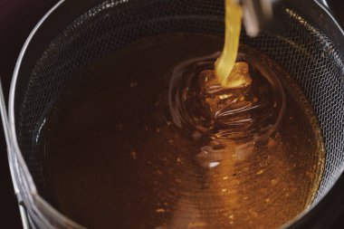 Siyah arka planda bal dolu bal kavanozu. Metnin için alanı kopyala. Kavanozdaki bal damlası indirme fotoğrafı