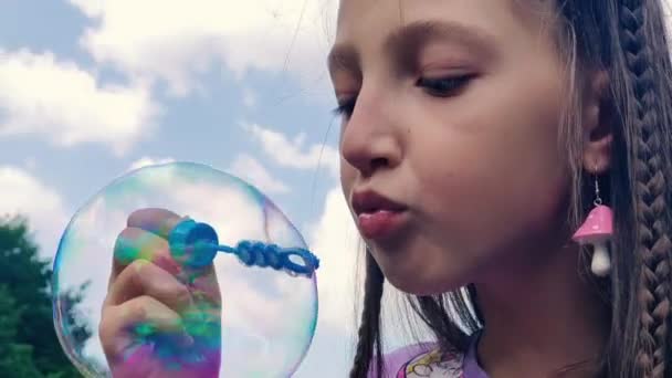 石鹸の泡を吹く小さな女の子 子供が石鹸の泡を吹く — ストック動画