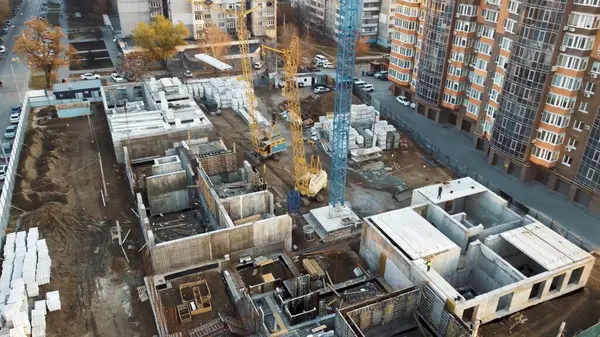 Çevrede tamamlanmış yüksek binalar ve boş arsalar var..