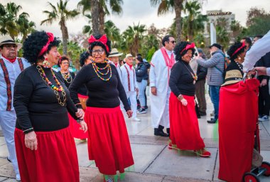 Renkli kostümler giymiş bir grup insan muhtemelen kutlama ya da festivale katılacaklar.