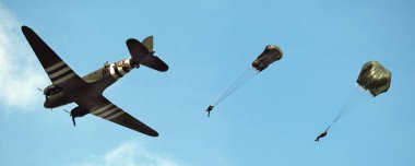 Zafer Şovu. Leicester, İngiltere, Eylül. Yaşayan ikinci dünya savaşı tarihi gösterisi ve hava gösterisi. Douglas C-47 Skytrain veya Dakota, Douglas DC-3 adlı sivil uçaktan geliştirilen bir askeri nakliye uçağıdır. Paraşüt birlikleri düşüyor..