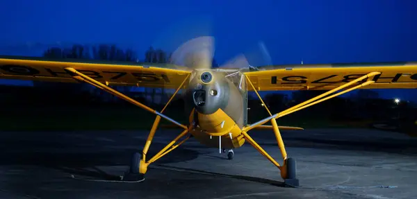 stock image Breighton, Selby, Yorkshire, UK. April 2024. Light aircraft running engine on the ground after dark.