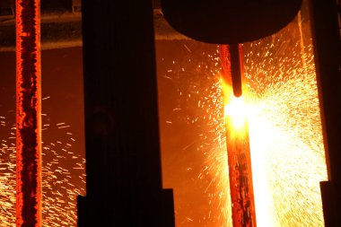 Çelik fabrikası, erimiş çeliği son rulo için şekillendirmeye devam ediyor..