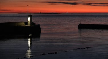 Northumberland 'da bir yaz akşamı. Holly Adası ve Farne Adaları 'nın olduğu deniz evleri ve Bamburgh sahili. İngiltere.