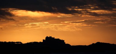 Northumberland 'da bir yaz akşamı. Holly Adası ve Farne Adaları 'nın olduğu deniz evleri ve Bamburgh sahili. İngiltere.