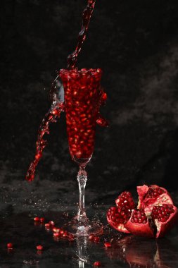 pomegranate wine in the glass on the black background