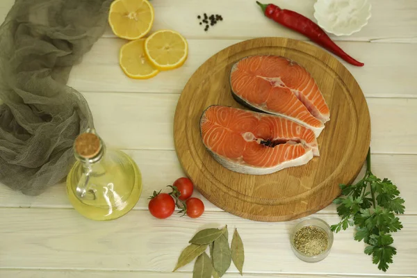 Fresh salmon steak with ingredients on  white wooden background