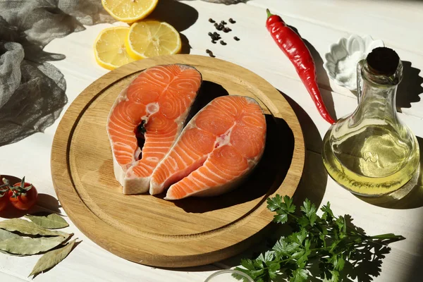 Fresh salmon steak with ingredients on  white wooden background