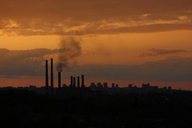 Ufukta şehir sınırı ve günbatımında güç istasyonu var.