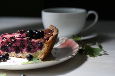 Mevsim meyveli fırınlanmış turta ve ahşap arka planda bir fincan kahve.