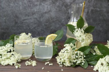 Yaşlı çiçeklerle dolu bir şişe limonata. Açık gri arkaplanda kopyalama alanı