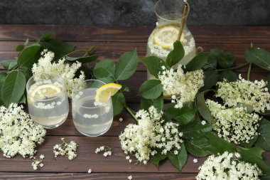 Yaşlı çiçeklerle dolu bir şişe limonata. Koyu ahşap arka planda doğa ile