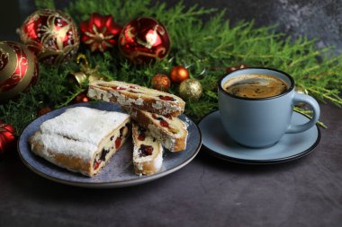 Dilimlenmiş Noel şekeri, noel süsü ve bir fincan kahveyle çalınmış.