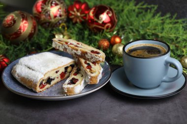 Dilimlenmiş Noel şekeri, noel süsü ve bir fincan kahveyle çalınmış.