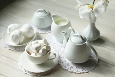 Marşmelov, kahve ve sütle bahar kahvaltısı. Beyaz renkli yiyecek ve çiçeklerle bembeyaz düzlük