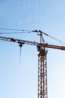 Mavi gökyüzüne karşı kocaman bir vinç kulesi. İnşaat arkaplanı