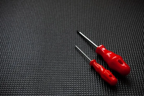 黑色背景的红色螺丝刀工作工业概念 — 图库照片