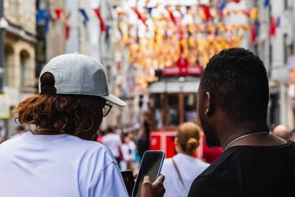 イスタンブールのイスタリックストリートで観光客のカップル 青背景色とともに赤ヴィンテージトラム — ストック写真
