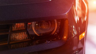 Bir arabanın farlarını yakın plan çekiyoruz. Otomobil farları. Modern araba ışıkları. Otomotiv aydınlatma sistemi