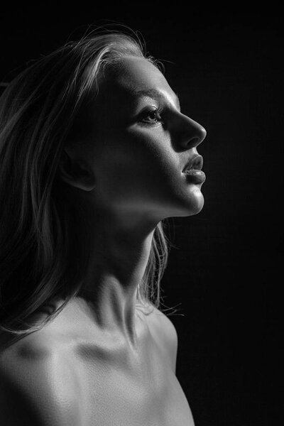 Dramatic black and white portrait of young blonde girl. Model studio photo