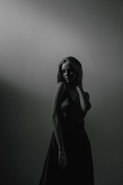 Zarif siyah elbiseli genç sarışın kız. Çekici modelin moda portresi