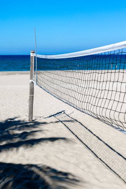 Voleybol sahası voleybol kalesiyle kumsalda. Yazın güneşli gökyüzü arkaplanı