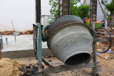 Bitmemiş temeli olan inşaat alanında paslı beton karıştırıcı.