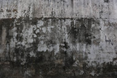 Eskimiş beton duvar, koyu lekeler ve yıpranmış doku..