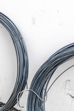 Beyaz duvar arkaplanına sarılı metal tel.