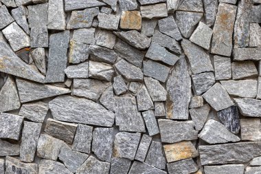 Natural stone wall texture with irregular grey slate pattern. clipart